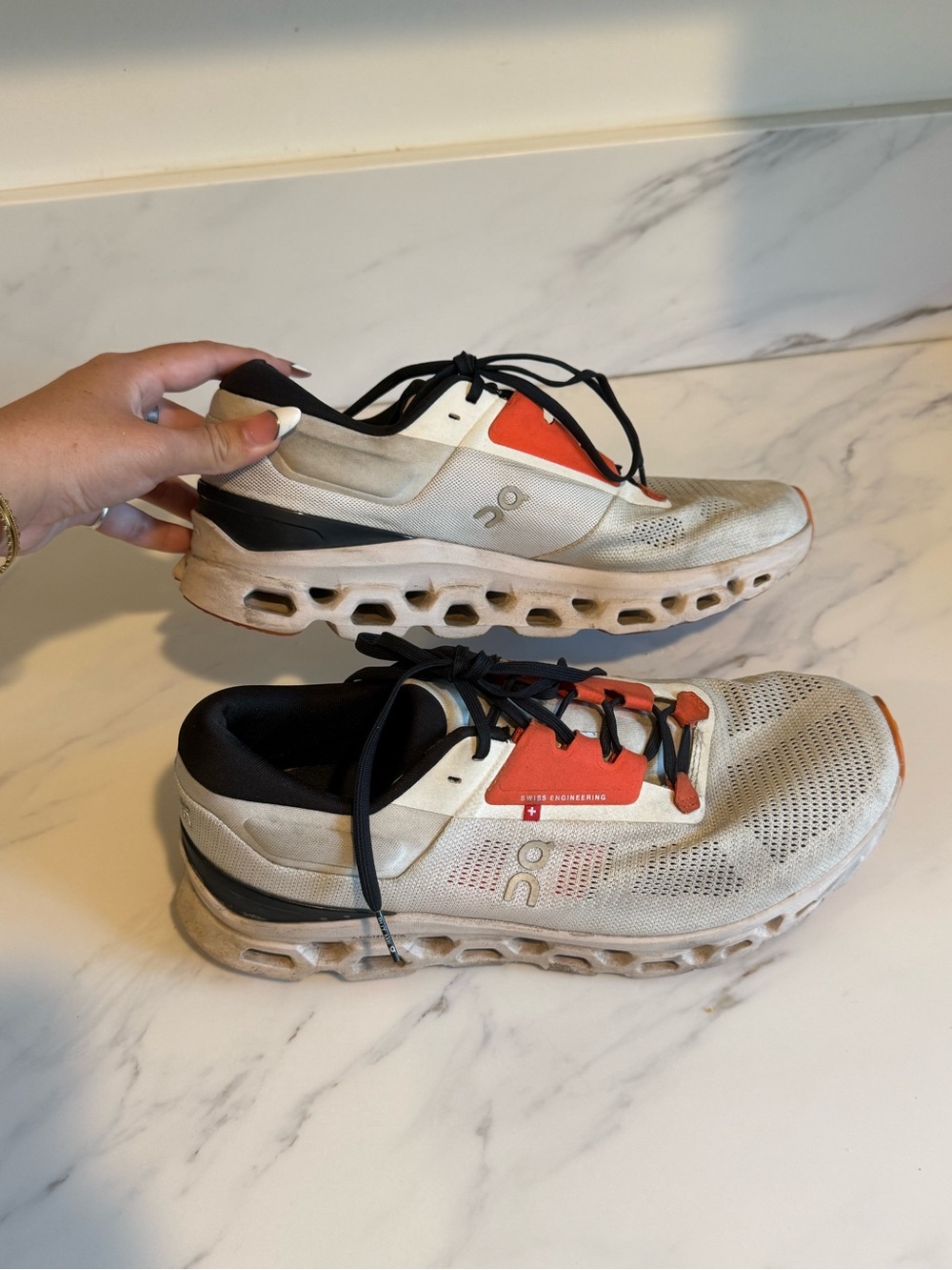 On cloud orange and white running shoes